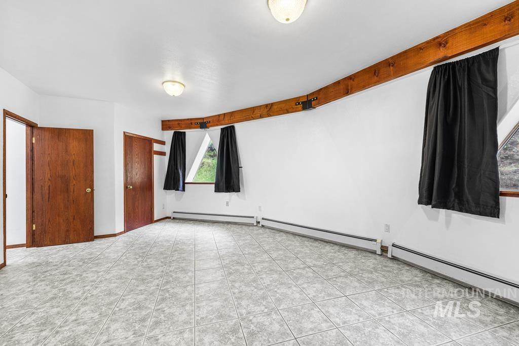 360 Lake Creek Riggins, ID 83549 - Photo 8 of 50 Unfurnished bedroom featuring a closet, a baseboard radiator, and light tile patterned floors