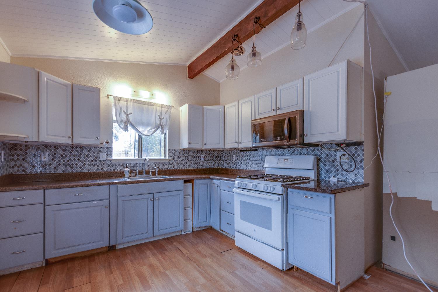 1570 East 26th Street Merced, CA 95340 - Photo 4 of 20 a kitchen with stainless steel appliances granite countertop a sink and stove top oven