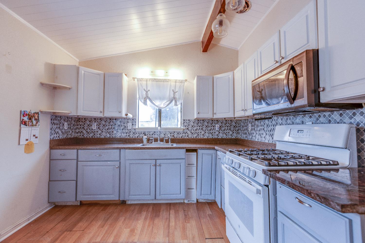 1570 East 26th Street Merced, CA 95340 - Photo 5 of 20 a kitchen with stainless steel appliances granite countertop wooden cabinets stove and sink