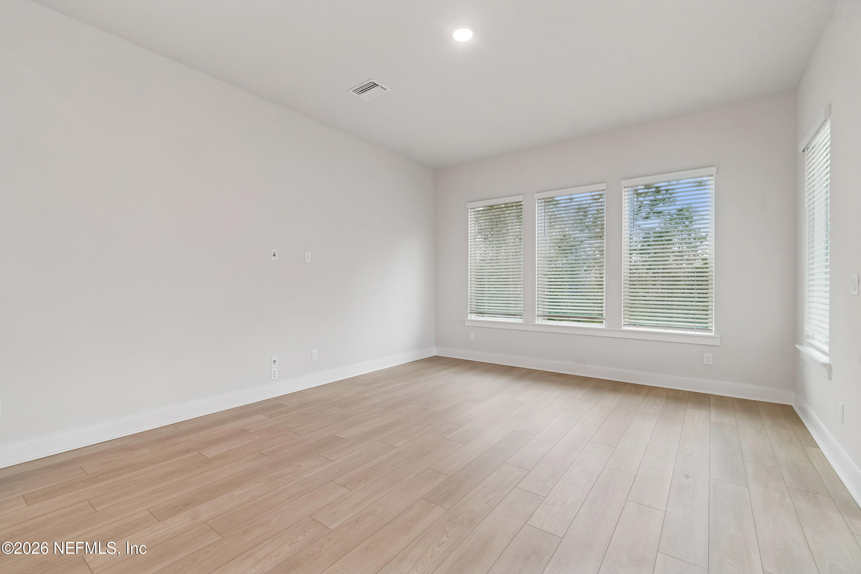 10165 Element Road Jacksonville, FL 32256 - Photo 11 of 25 an empty room with wooden floor and windows