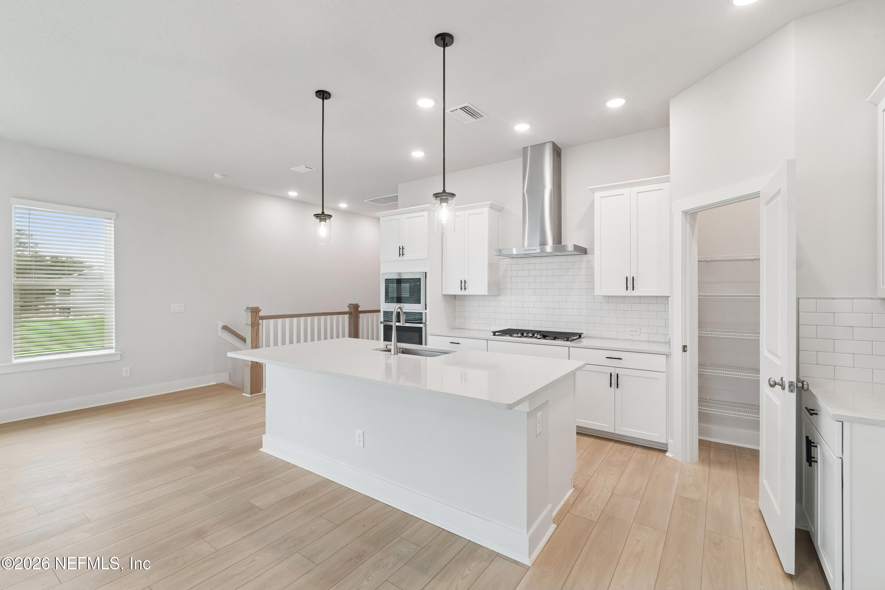 10165 Element Road Jacksonville, FL 32256 - Photo 5 of 25 a large kitchen with kitchen island a stove a sink a center island and wooden floor