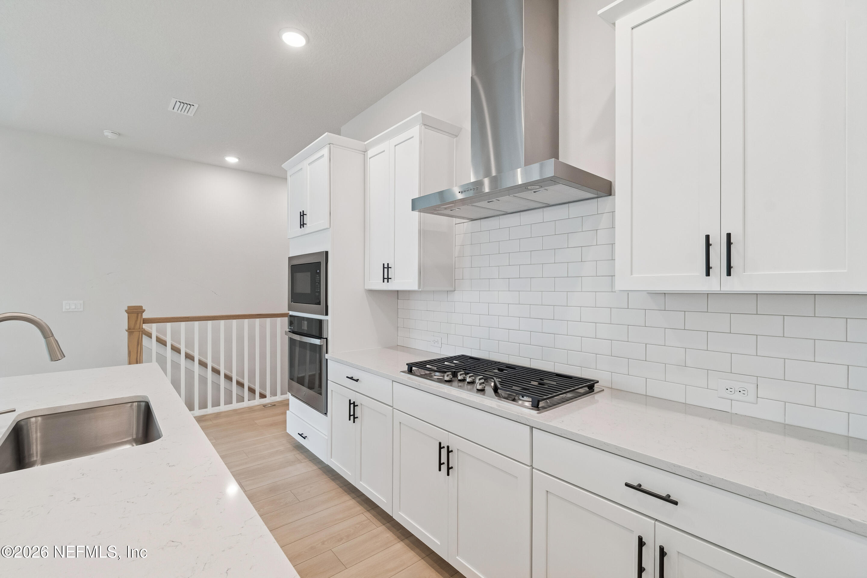 10165 Element Road Jacksonville, FL 32256 - Photo 6 of 25 a kitchen with granite countertop a stove a sink and white cabinets