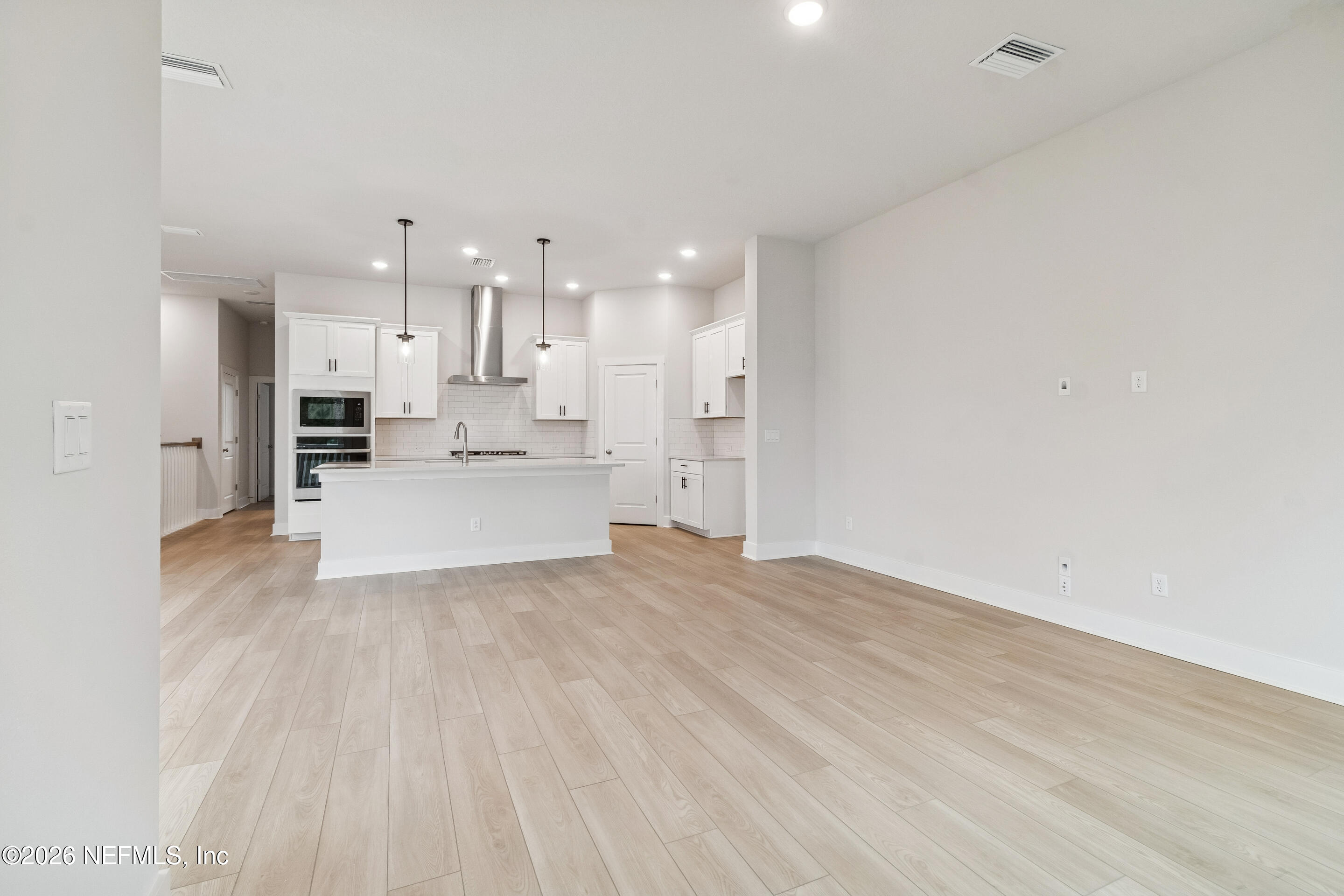 10165 Element Road Jacksonville, FL 32256 - Photo 8 of 25 a large white room with kitchen island a sink wooden floor and view living room
