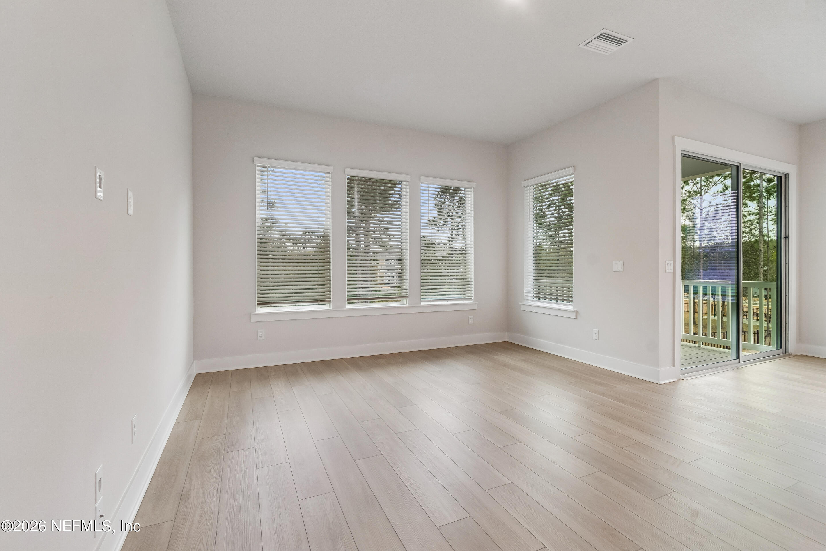 10165 Element Road Jacksonville, FL 32256 - Photo 10 of 25 a view of an empty room with wooden floor and a window
