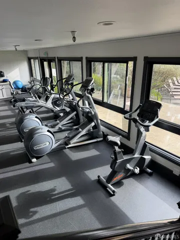a room with gym equipment and floor to ceiling window