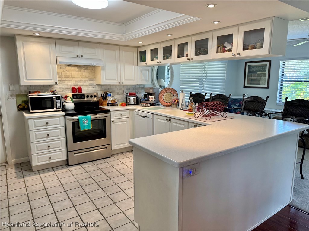 3401 Divot Road Sebring, FL 33872 - Photo 12 of 29 a kitchen with stainless steel appliances a stove a sink a microwave and cabinets