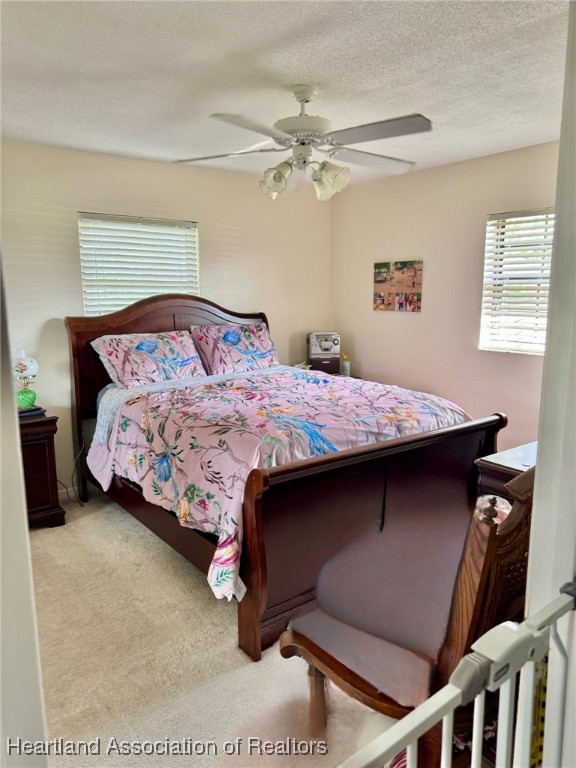 3401 Divot Road Sebring, FL 33872 - Photo 20 of 29 a bedroom with a bed and a chandelier