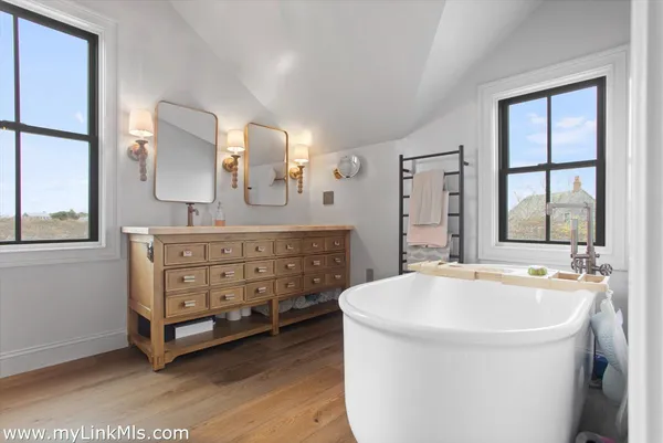 a spacious bathroom with a tub sink and mirror