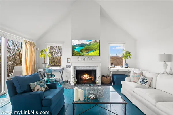 a living room with furniture a fireplace and a flat screen tv