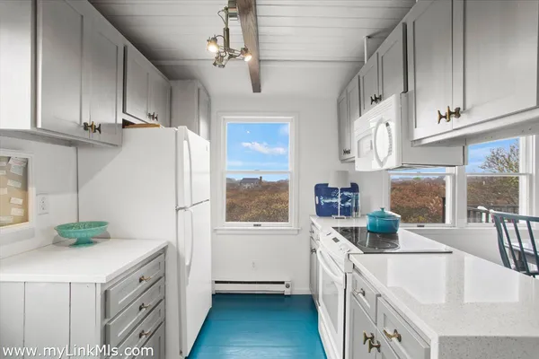 a kitchen with stainless steel appliances a white cabinets wooden floor and a sink