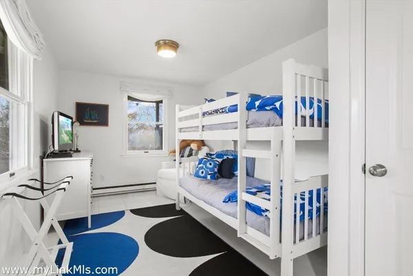 a bedroom with baby crib and a window