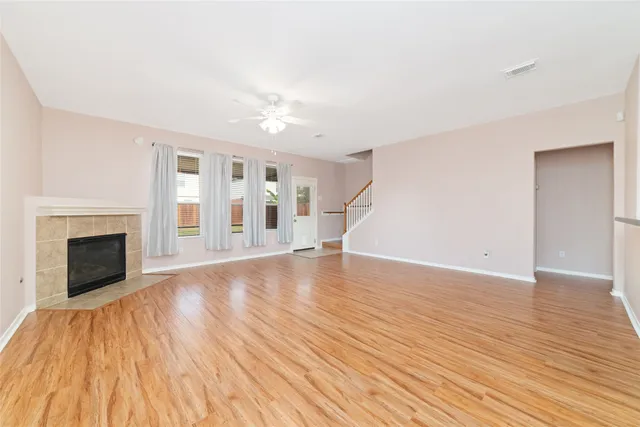 a view of empty room with wooden floor and fireplace