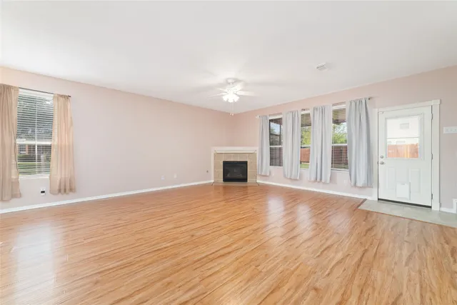 a view of an empty room with glass door and wooden floor