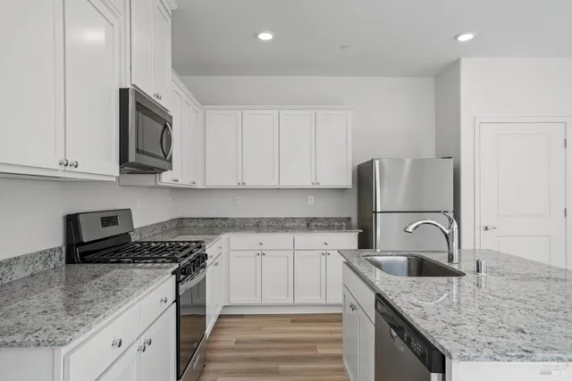 a kitchen with granite countertop a sink and a stove top oven