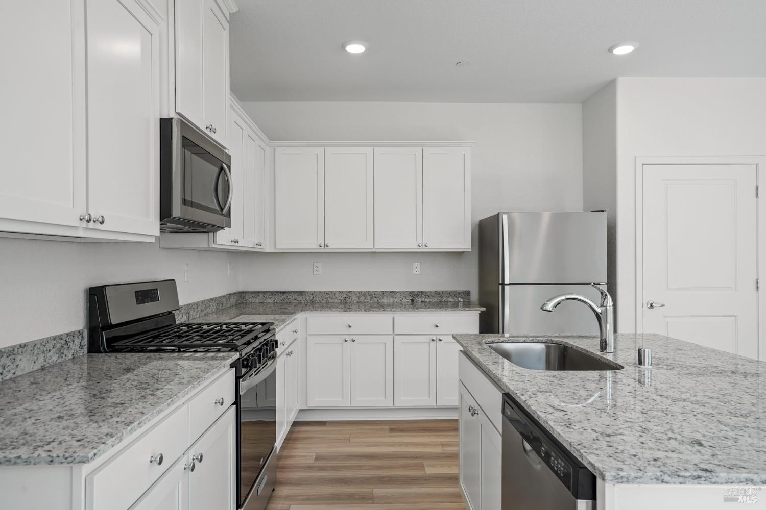 2220 Front Porch Lane Rio Vista, CA 94571 - Photo 4 of 15 a kitchen with granite countertop a sink and a stove top oven