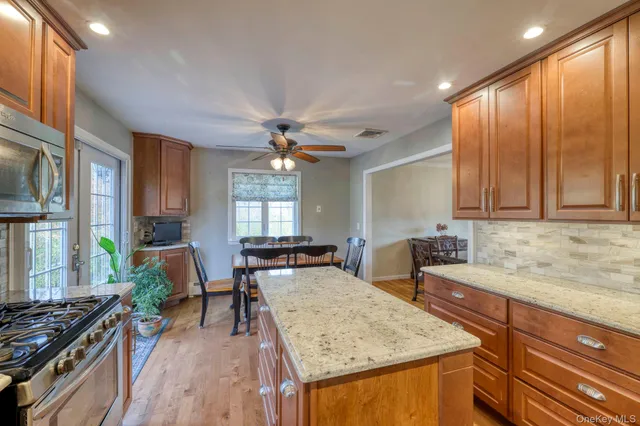 a kitchen with stainless steel appliances granite countertop wooden cabinets a stove top oven a sink and dishwasher