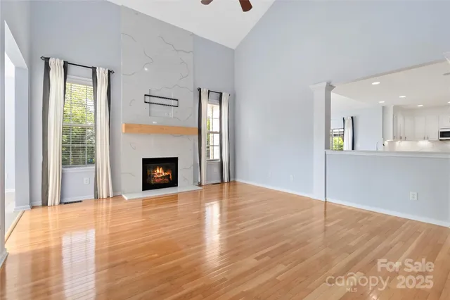 a view of an empty room with window and fire place