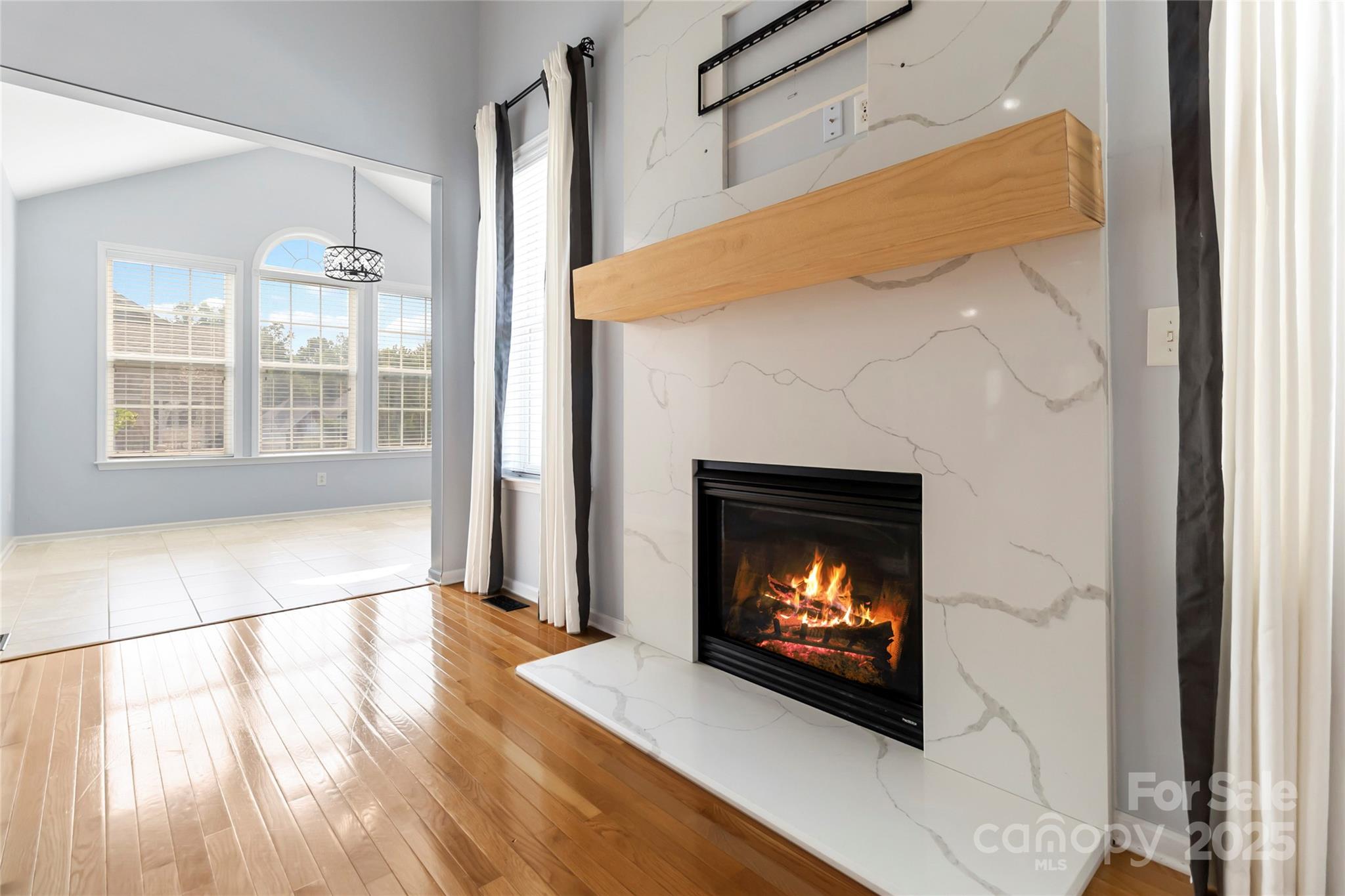 1009 Murandy Lane Matthews, NC 28104 - Photo 13 of 48 a view of an empty room with wooden floor fireplace and a window