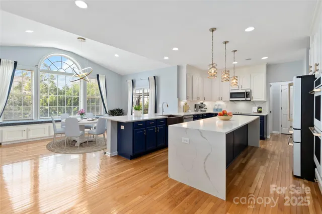 a kitchen with kitchen island granite countertop a large counter top stainless steel appliances and windows