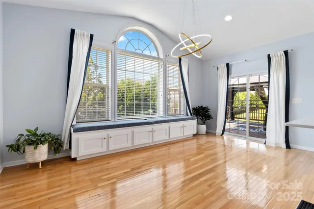 a view of empty room with front door and wooden floor