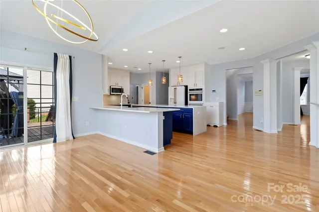 a big room with stainless steel appliances kitchen island granite countertop a refrigerator and a sink