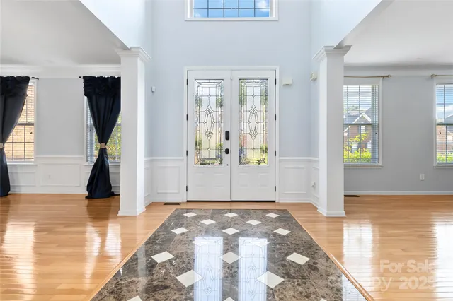 a view of a hallway with wooden floor and a living room