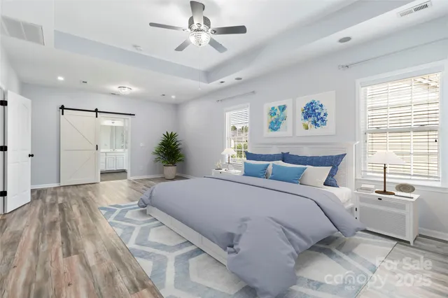 a spacious bedroom with a large bed a chandelier and a window