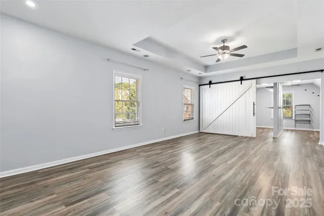 a view of empty room with wooden floor and fan