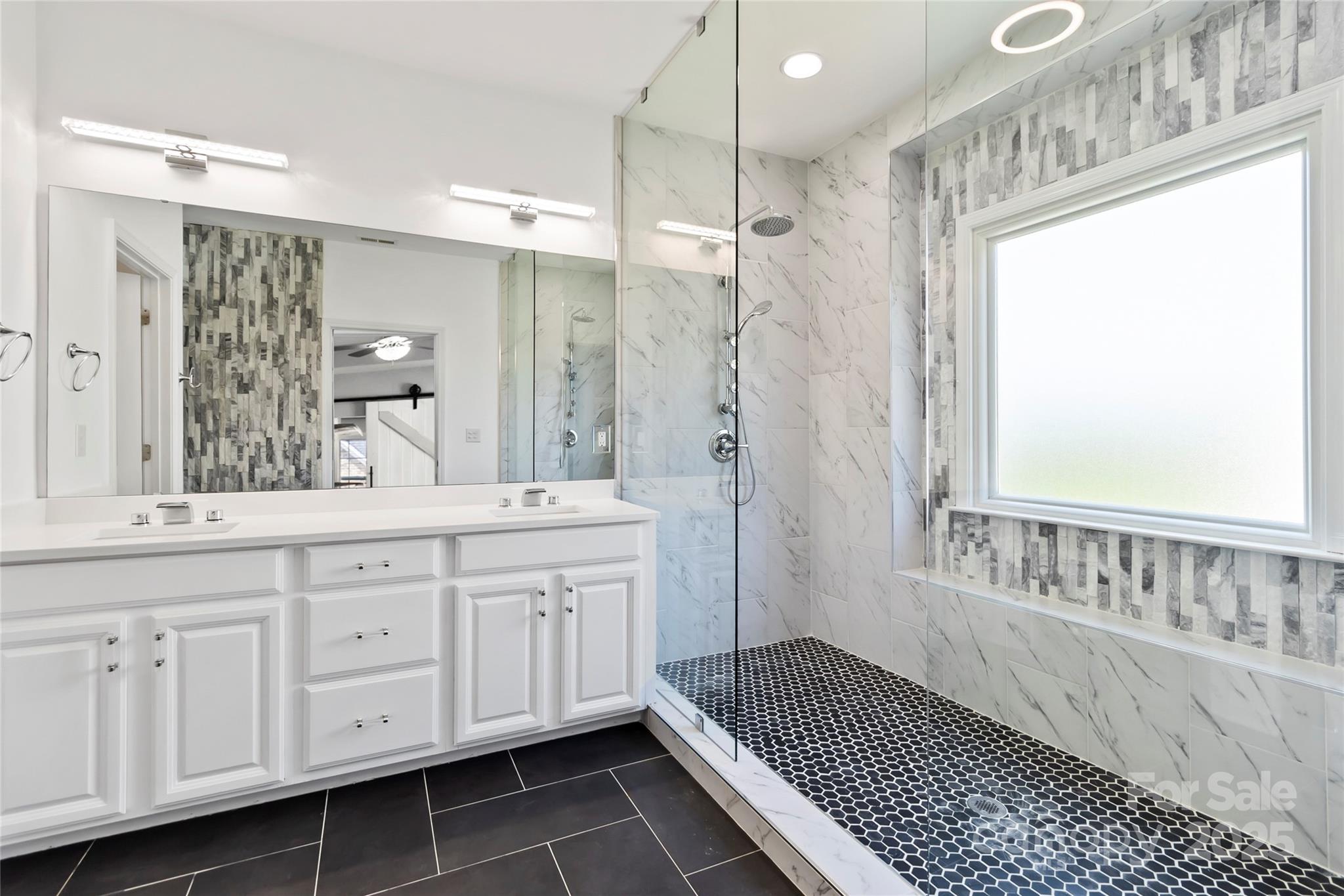 1009 Murandy Lane Matthews, NC 28104 - Photo 36 of 48 a spacious bathroom with a shower a sink and a mirror