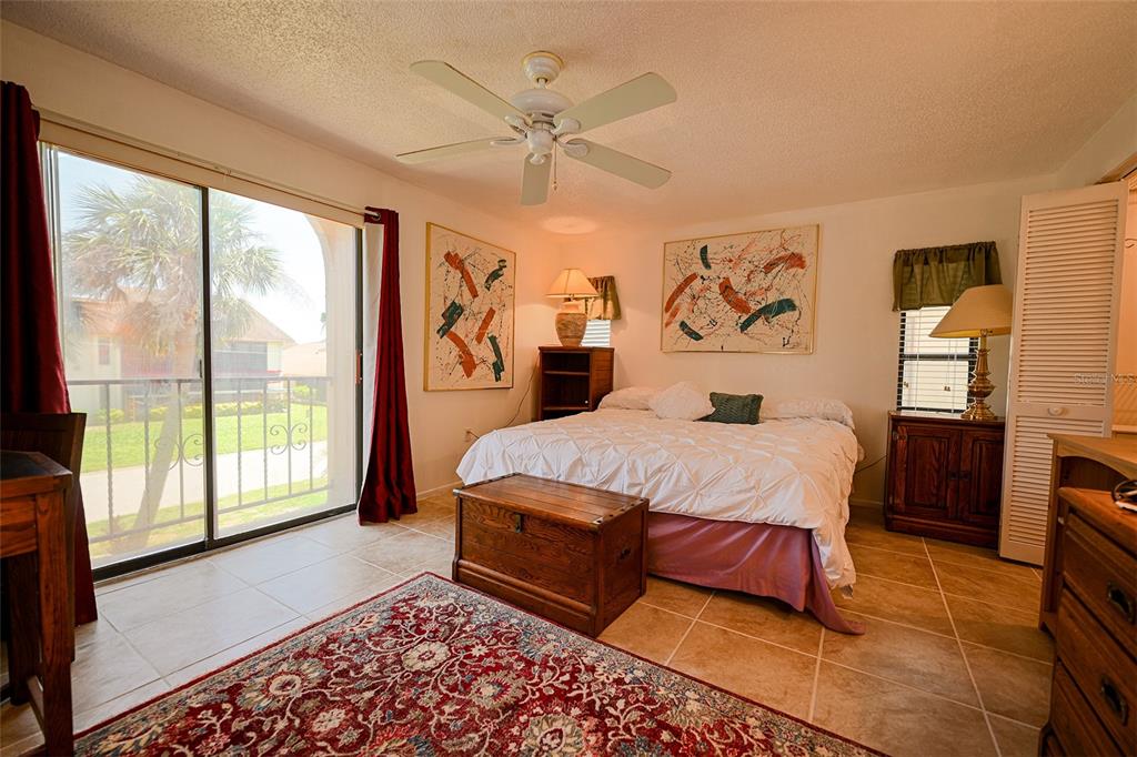 1731 Bonitas Circle, Unit 1720C Venice, FL 34293 - Photo 11 of 21 a spacious bedroom with a large bed and a chandelier