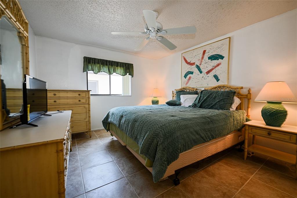 1731 Bonitas Circle, Unit 1720C Venice, FL 34293 - Photo 15 of 21 a bedroom with a bed and dresser with mirror