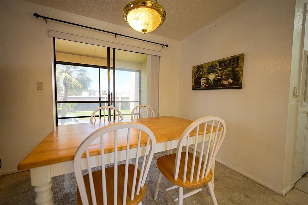 1731 Bonitas Circle, Unit 1720C Venice, FL 34293 - Photo 4 of 21 a view of a dining room with furniture wooden floor and chandelier