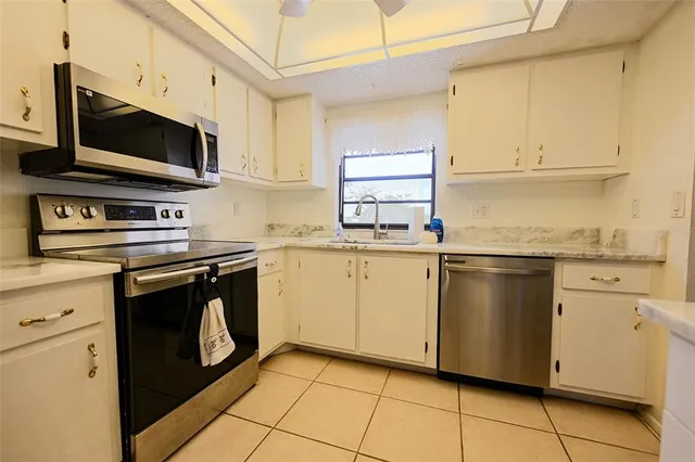 a kitchen with a sink a stove top oven a refrigerator and cabinets