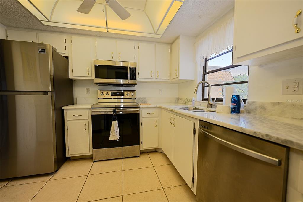 1731 Bonitas Circle, Unit 1720C Venice, FL 34293 - Photo 10 of 21 a kitchen with a stove a sink and a refrigerator