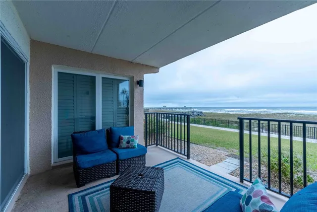 a view of a balcony with furniture and a floor to ceiling window