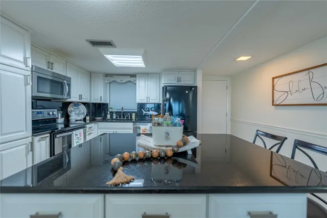 a kitchen with stainless steel appliances granite countertop a sink refrigerator and cabinets