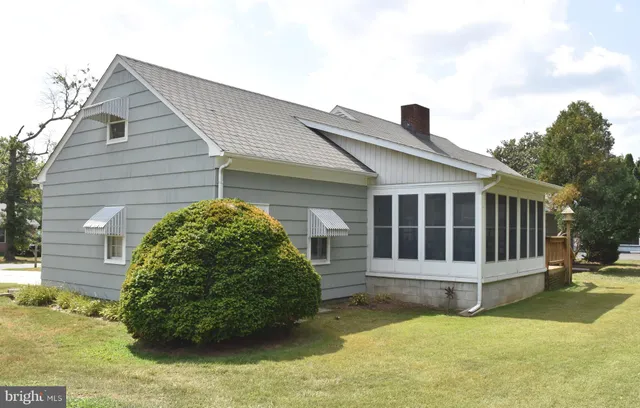 a view of a house with a yard and large tree