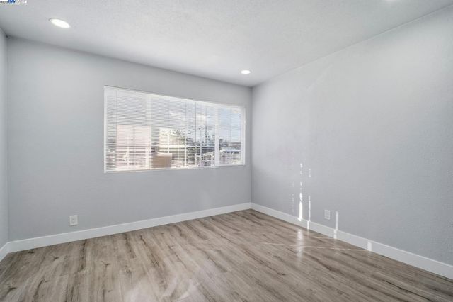 an empty room with wooden floor and door
