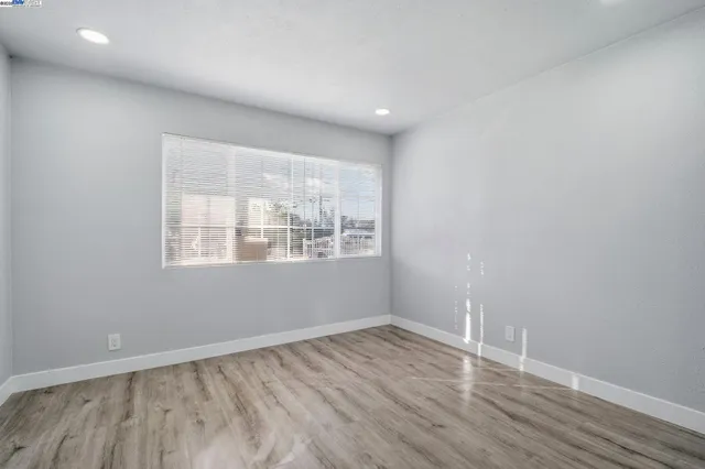 an empty room with wooden floor and door