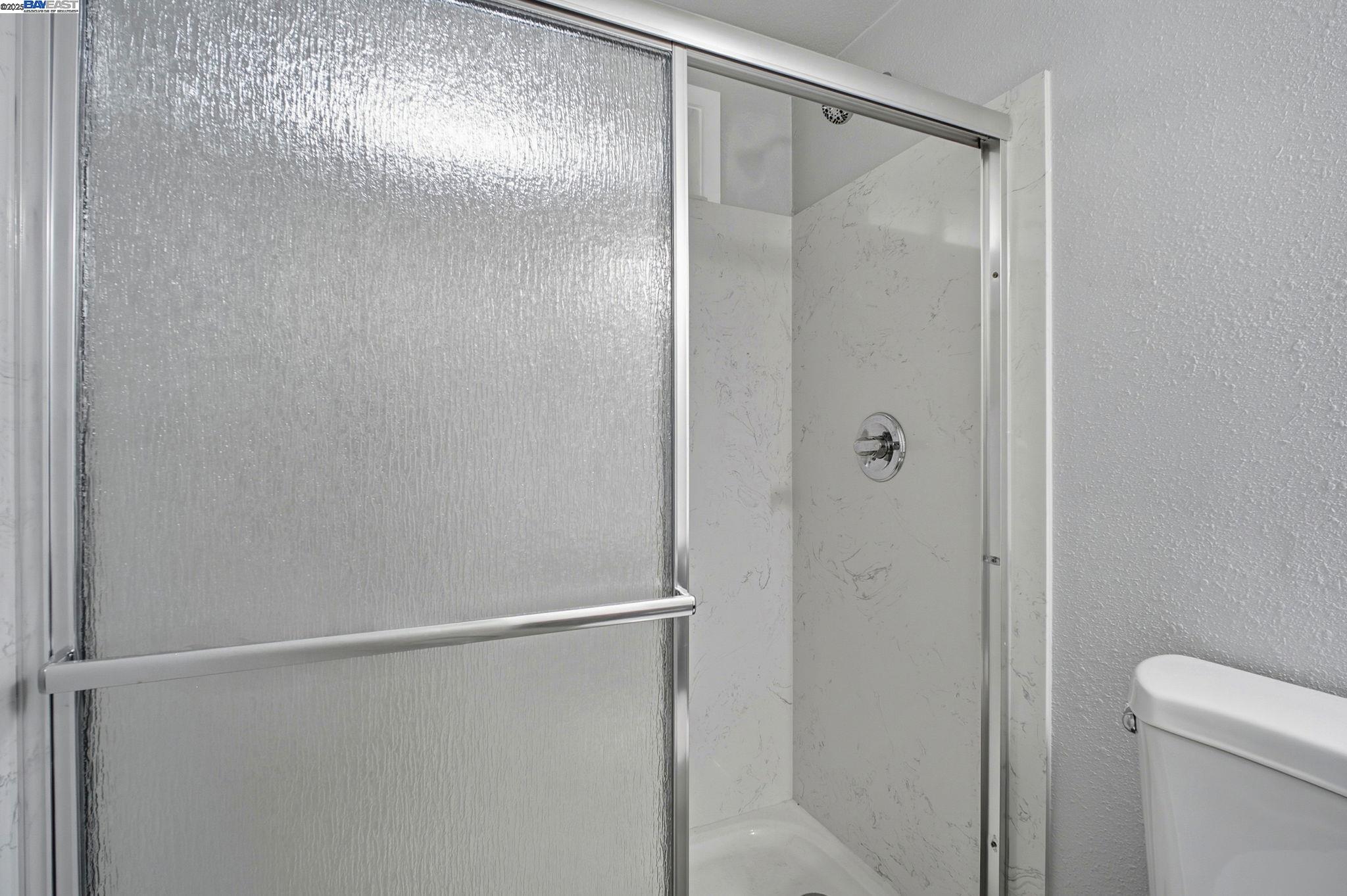 38016 Vallejo Street Fremont, CA 94536 - Photo 19 of 32 a bathroom with a glass shower door