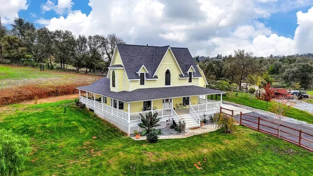 an aerial view of residential houses with outdoor space and trees
