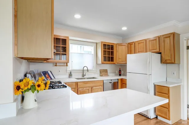 a kitchen with stainless steel appliances granite countertop a sink refrigerator and cabinets