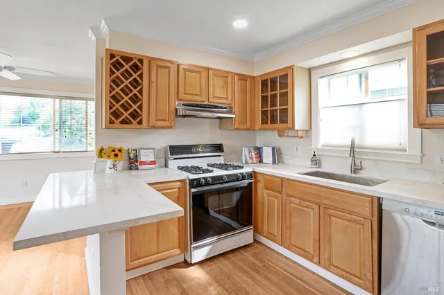 a kitchen with stainless steel appliances granite countertop a stove a sink and a microwave
