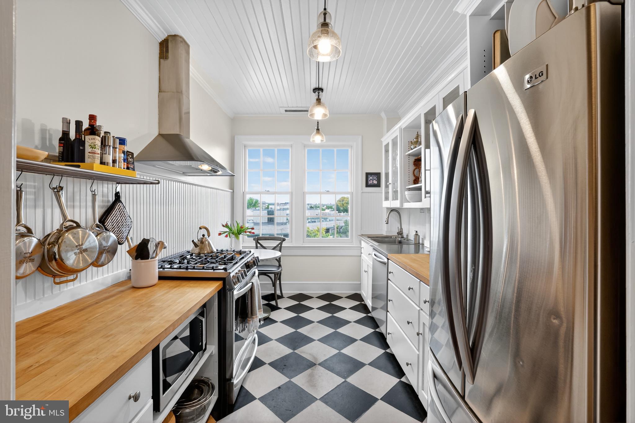 1661 Crescent Place Northwest, Unit 604 Washington, DC 20009 - Photo 31 of 61 a kitchen with kitchen island a counter space a sink a window and stainless steel appliances