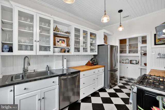 a kitchen with granite countertop stainless steel appliances a sink and a refrigerator
