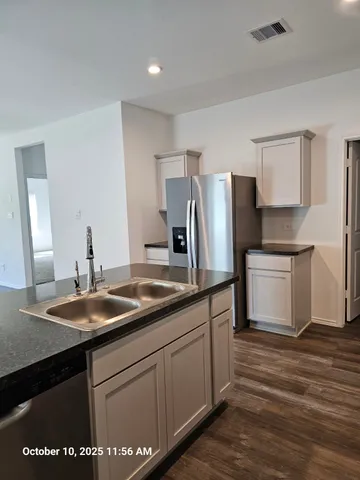 a kitchen with a sink a refrigerator and cabinets