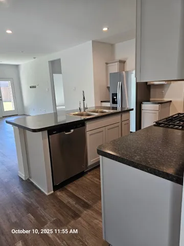 a kitchen with granite countertop a sink and a refrigerator