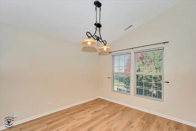 a view of a room with a large window and wooden floor