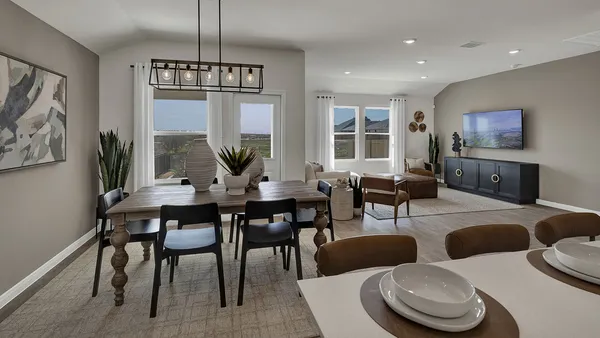 a view of a dining room with furniture a livingroom and chandelier