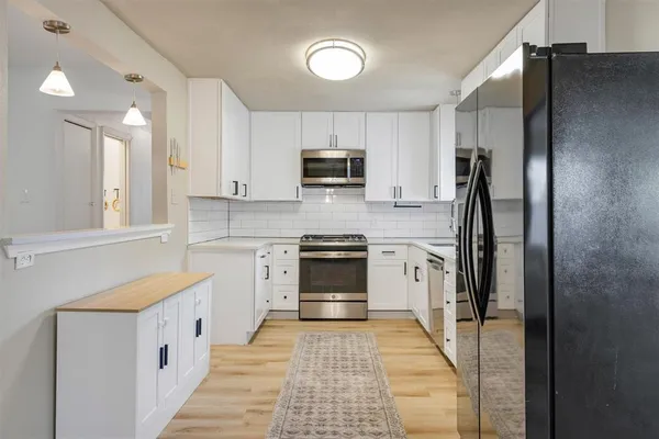 a kitchen with stainless steel appliances granite countertop a stove a refrigerator and a stove